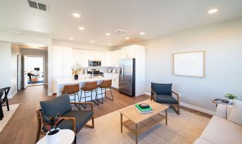 A living room with a kitchen and dining area. A living room with a kitchen and dining area.