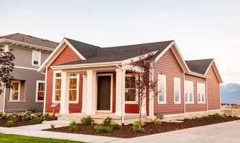 A red and white house with a lawn in front of it. A red and white house with a lawn in front of it.