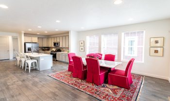 A kitchen and dining room with red chairs. A kitchen and dining room with red chairs.