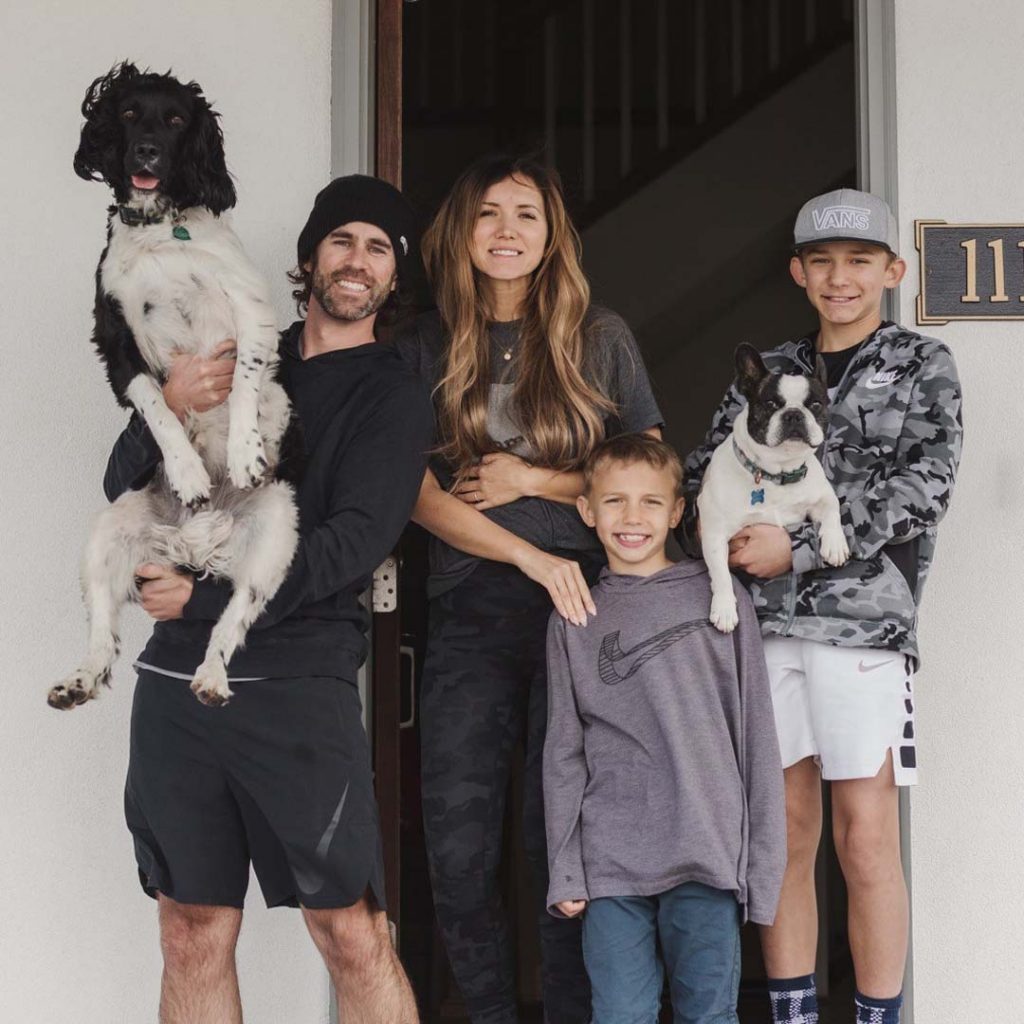 Family standing on front porch with their dogs in Daybreak.