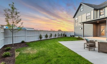 A backyard with a white fence and a table and chairs. A backyard with a white fence and a table and chairs.