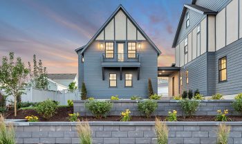 A home with a gray siding and a stone wall. A home with a gray siding and a stone wall.