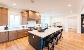 A kitchen with a center island and bar stools. A kitchen with a center island and bar stools.