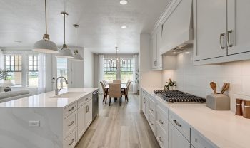 A kitchen with white cabinets and counter tops. A kitchen with white cabinets and counter tops.