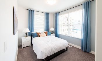 A bedroom with blue curtains and a bed, located in Manhattan. A bedroom with blue curtains and a bed, located in Manhattan.