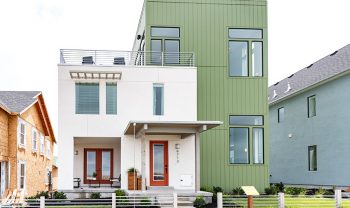 A green house with a white fence. A green house with a white fence.