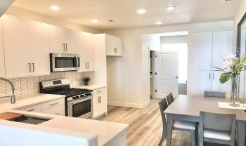 A kitchen with white cabinets and hardwood floors. A kitchen with white cabinets and hardwood floors.