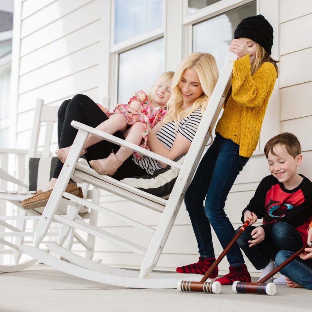 Mother laughs with her three children while sitting in a rocking chair | South Jordan, Utah.